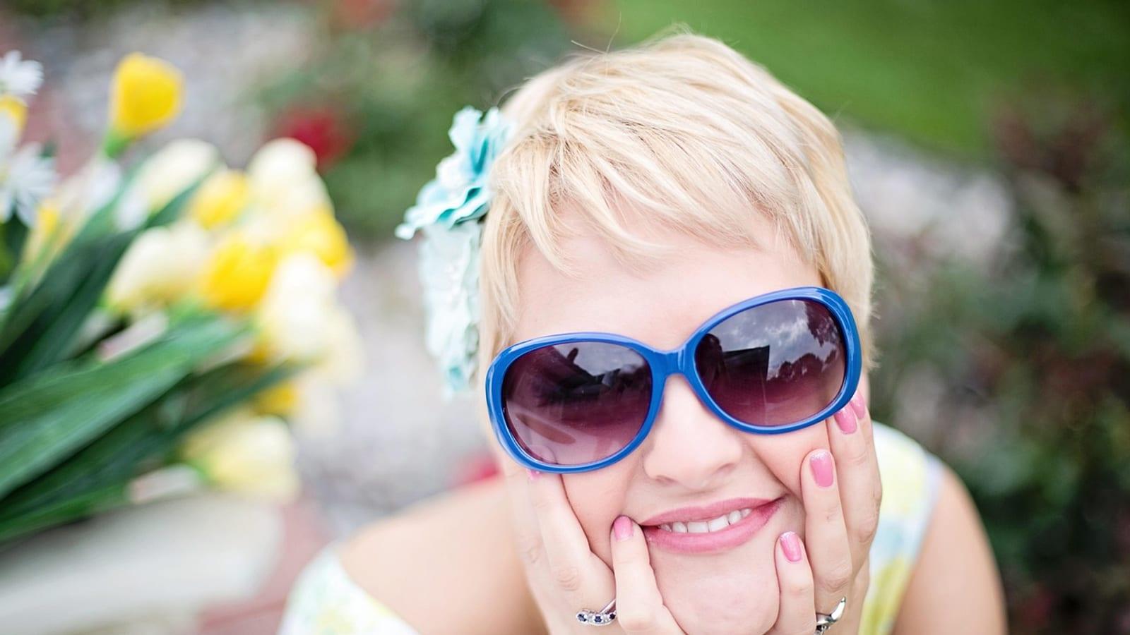 Blonde woman with short hair, smiling in sunlight