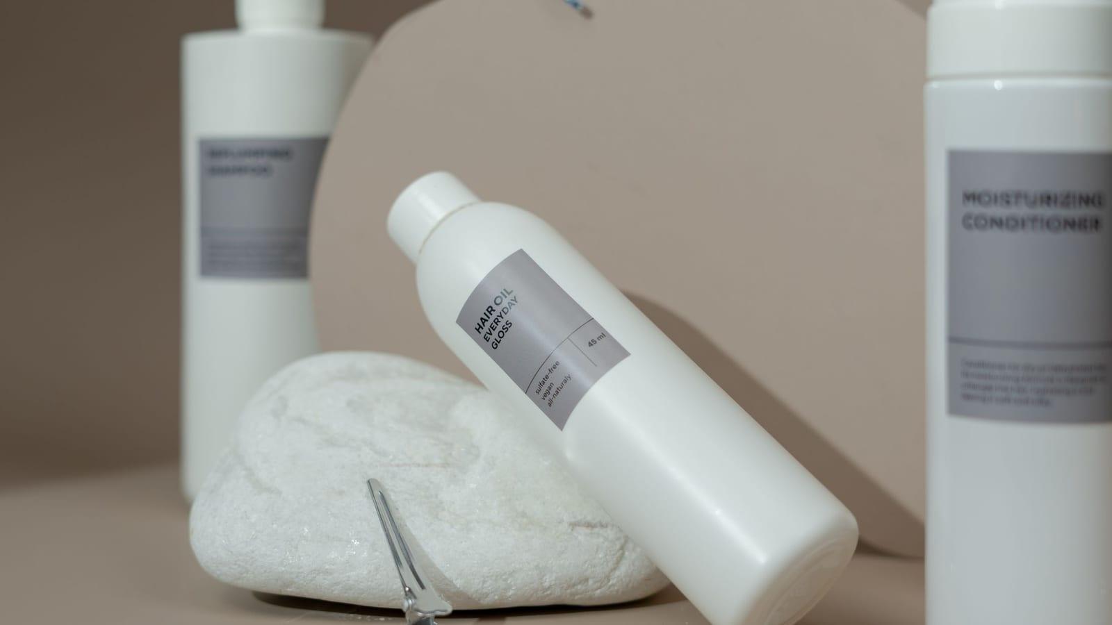 Sulfate-free cleanser and conditioner bottles with a hair clip on a neutral counter