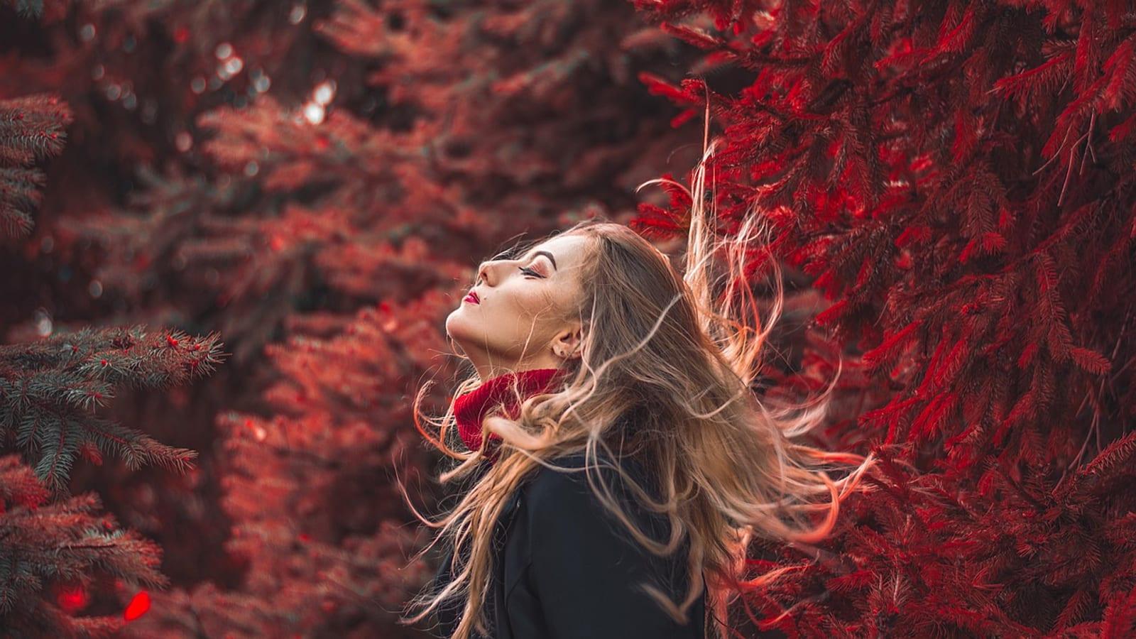 Woman with long red hair in autumn nature, portrait