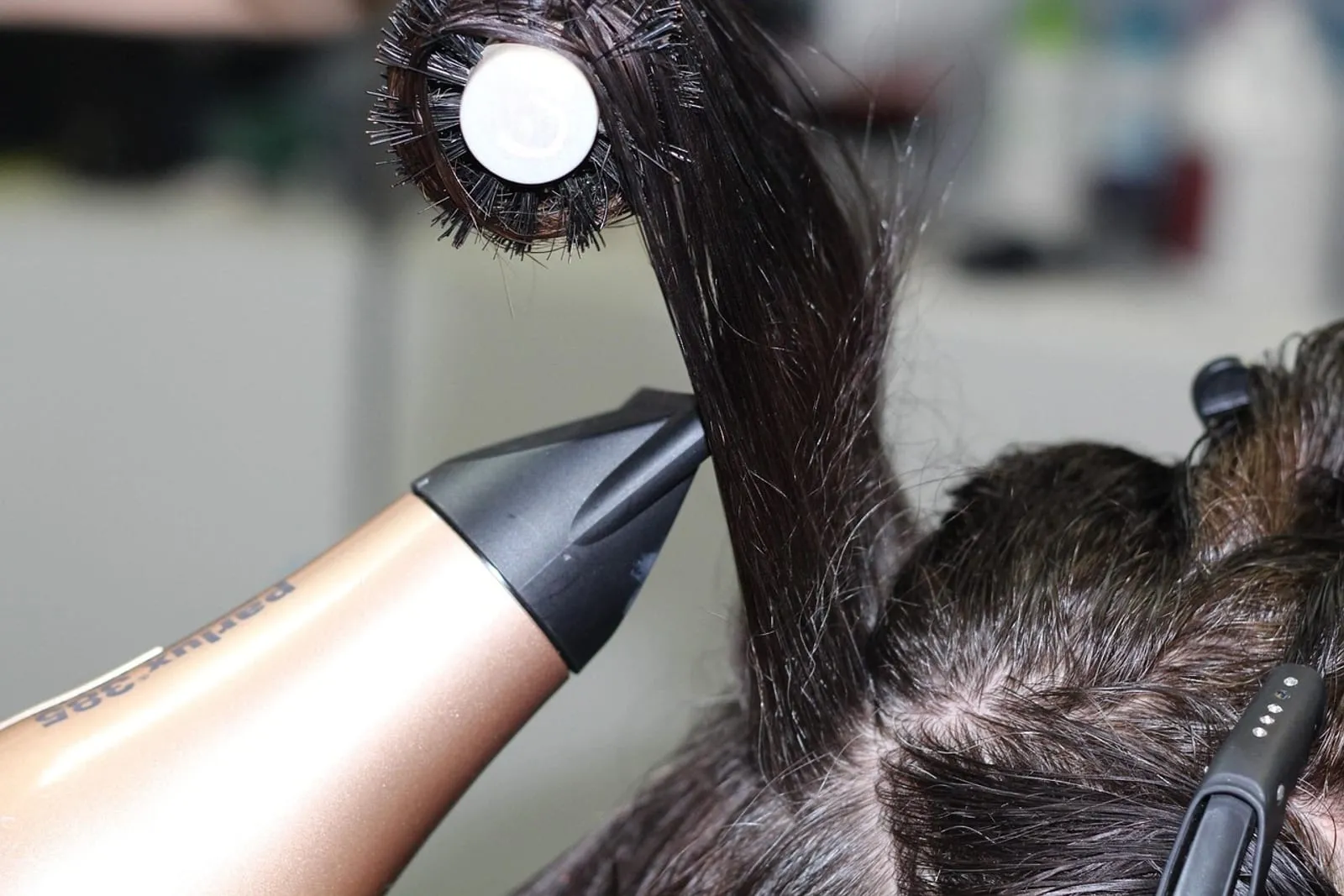 Stylist working on a woman's hair in a salon
