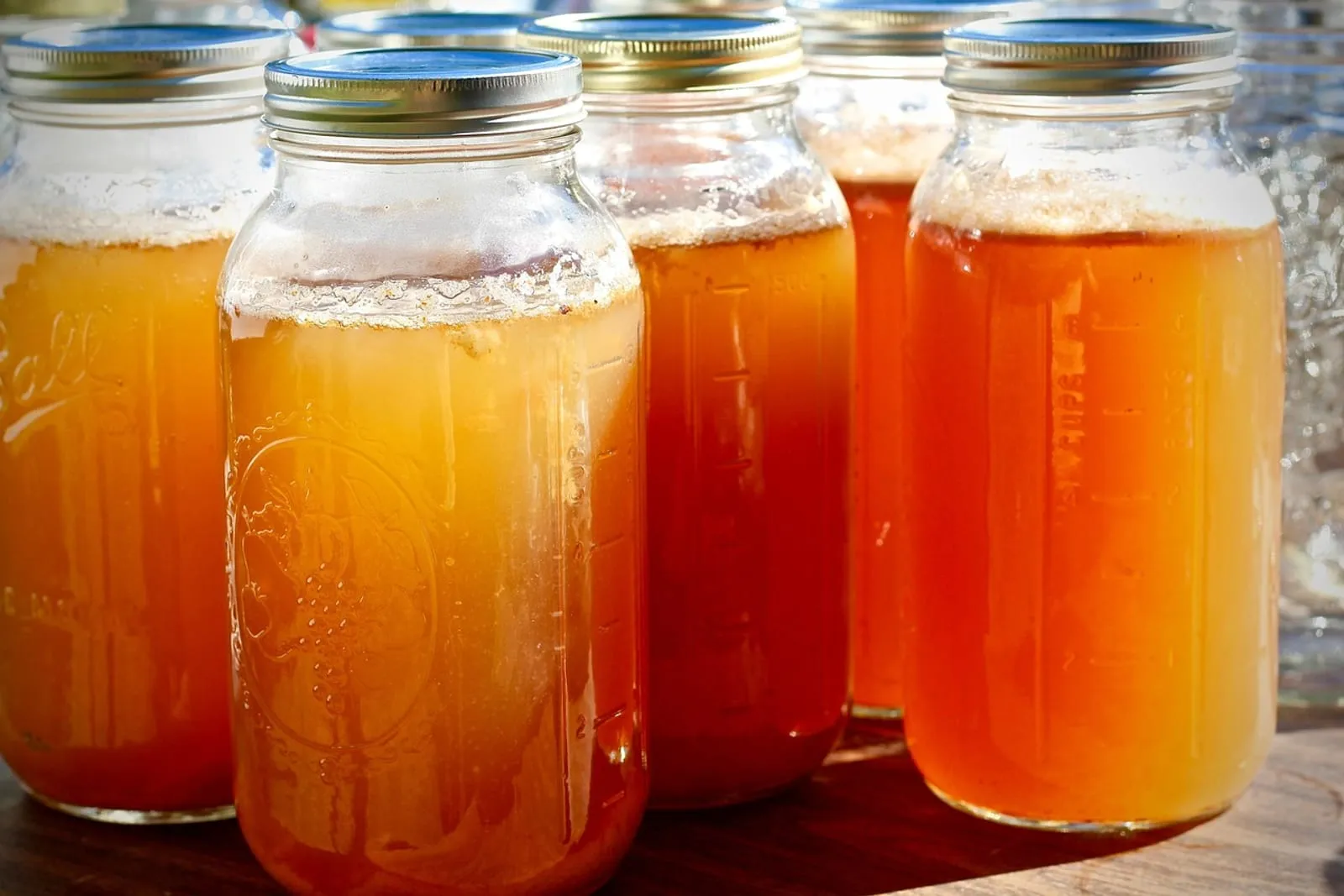 Glass jars of homemade apple cider on a counter