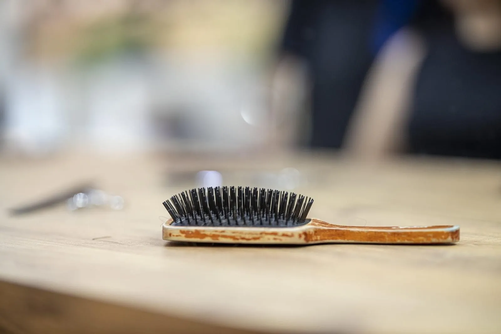 Woman with a wooden comb and hair brush in a living room