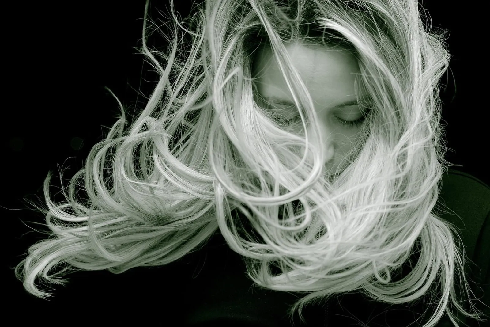 Woman with blonde long hair in portrait, close-up