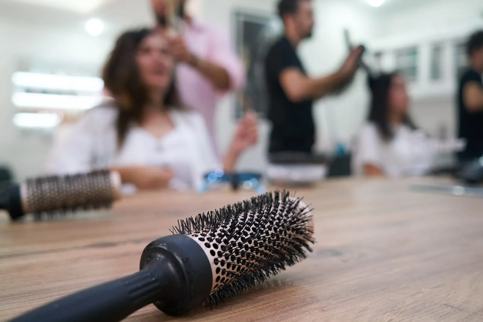 Woman hairdresser cutting hair with scissors and a comb