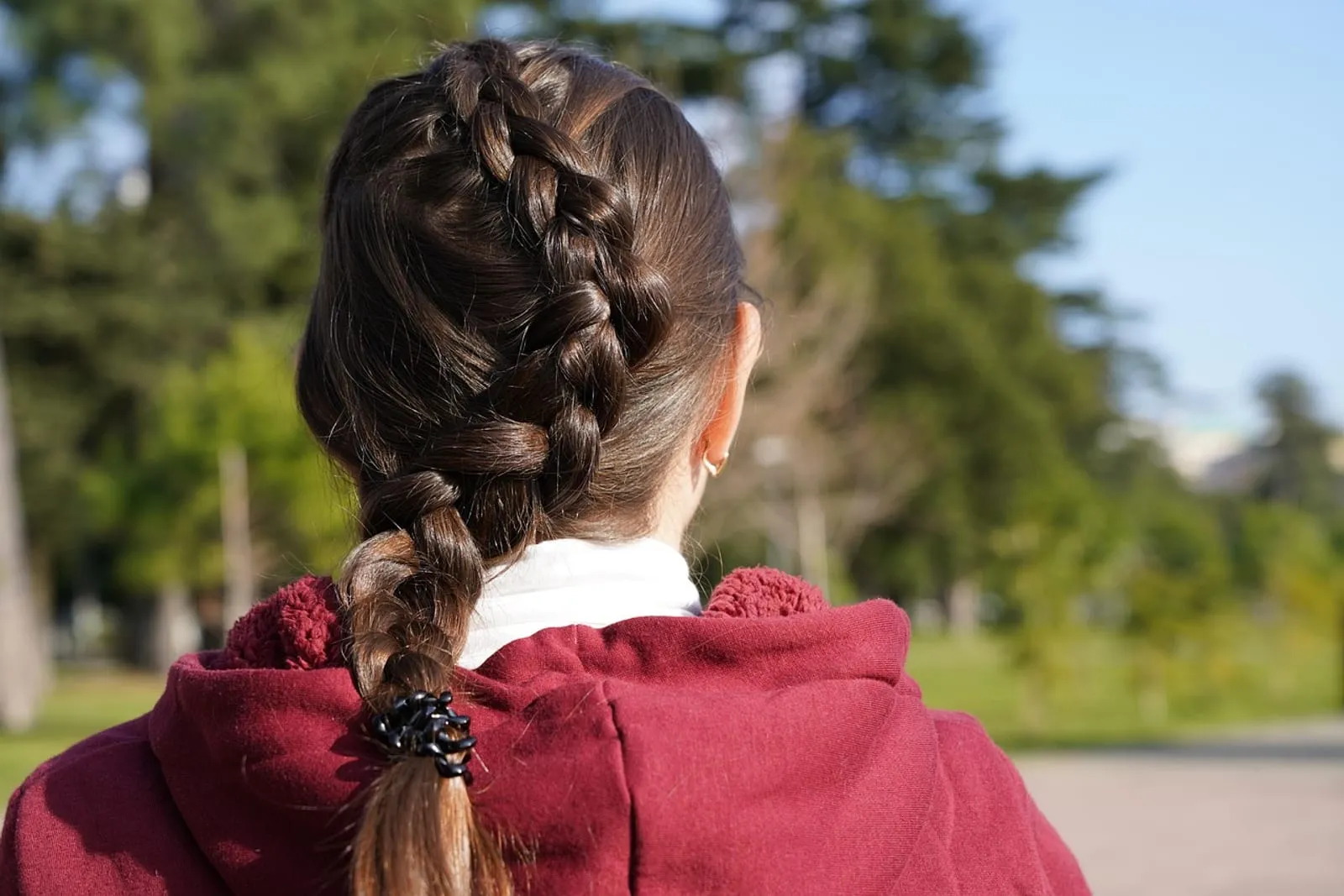 Close-up of a woman's hair styled in neat braids, soft focus background