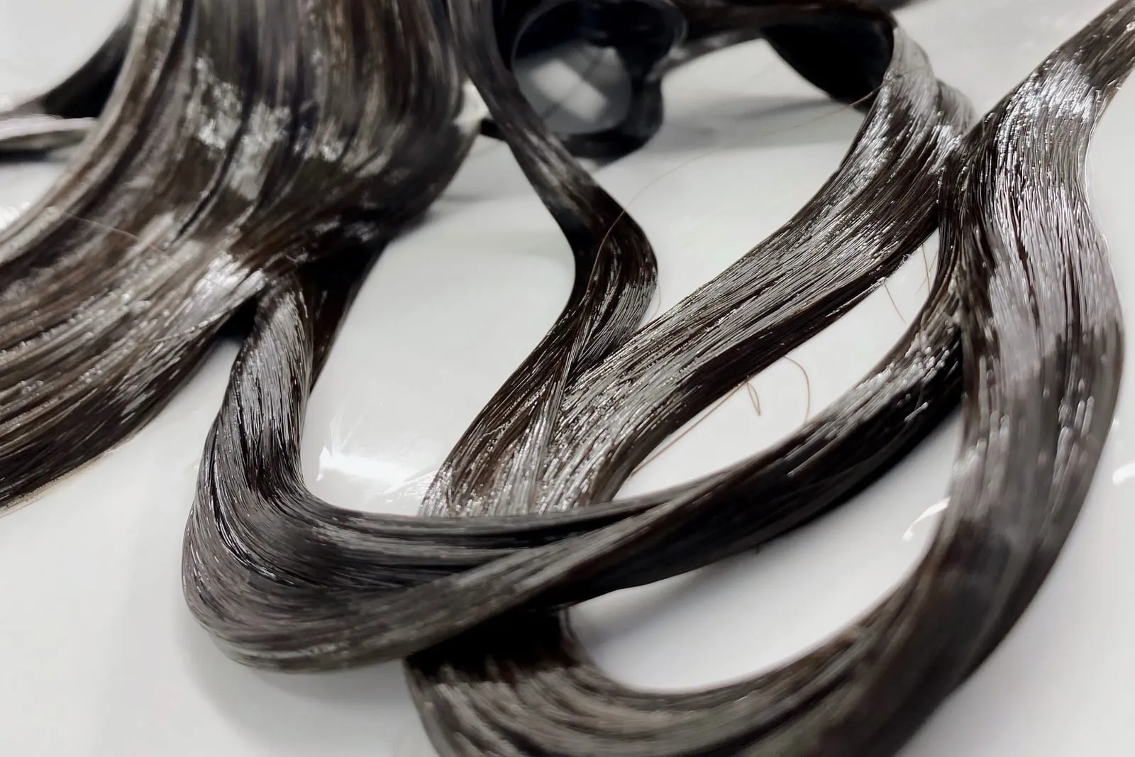 Long dark hair coated in a thick, glossy layer of conditioner