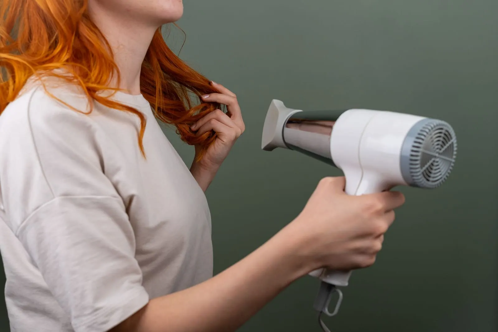 Woman drying her hair with a hair dryer on a low setting