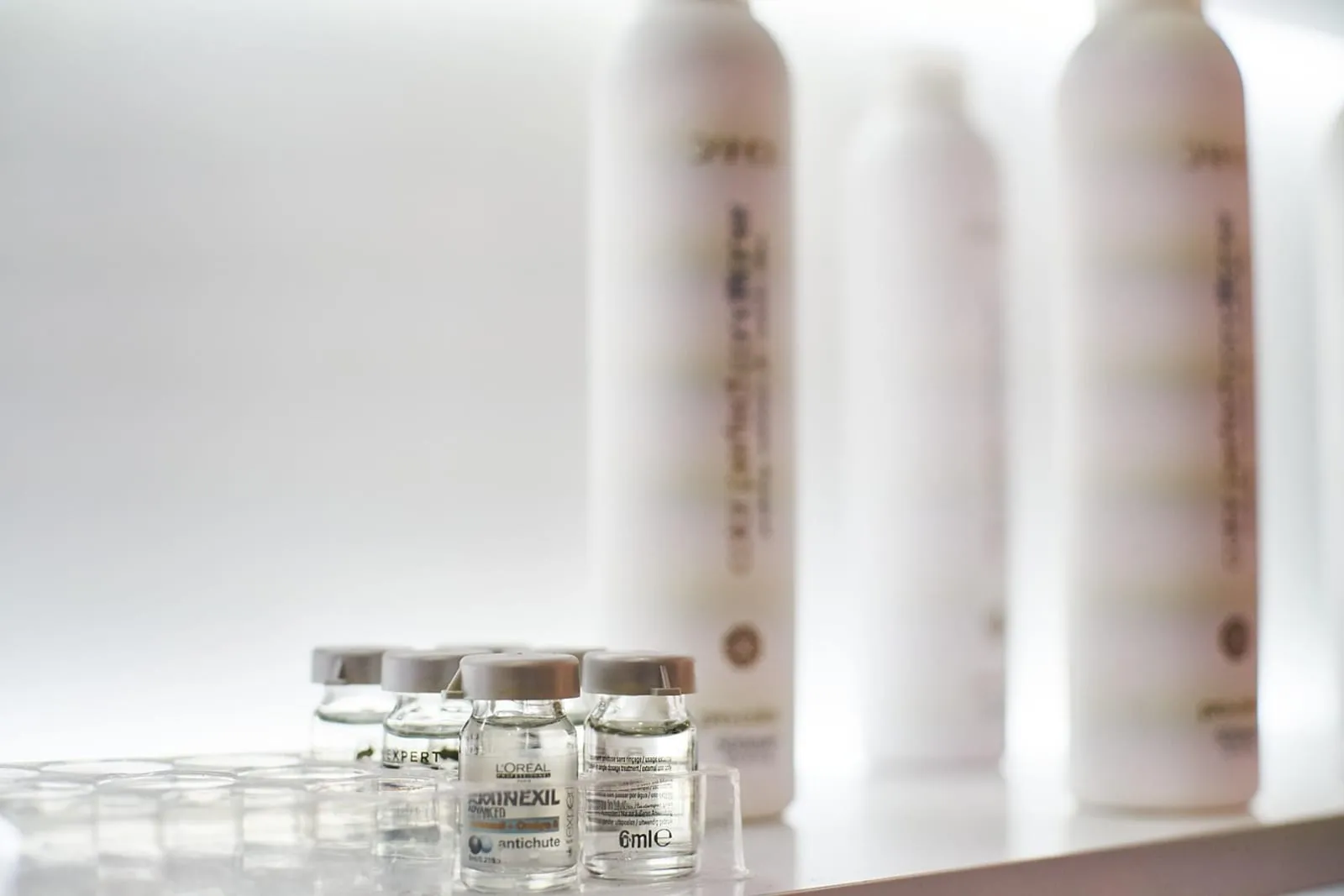 Woman with long hair holding a hair serum bottle