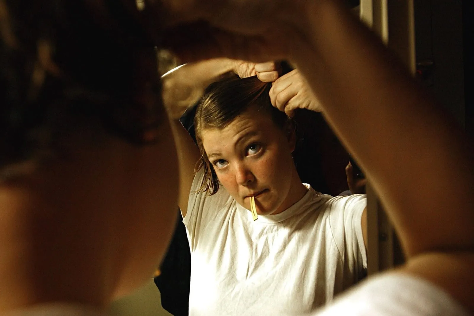 Woman styling her hair in front of a mirror