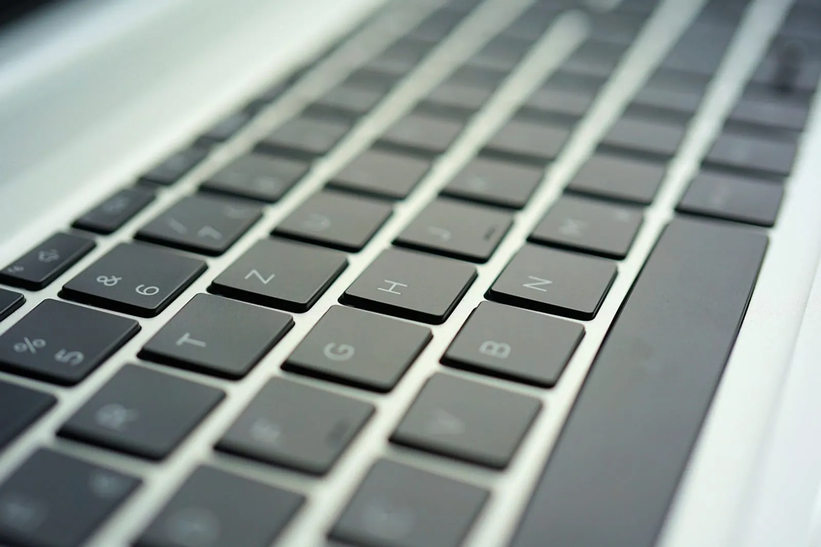 Close-up of a silver laptop with a black keyboard